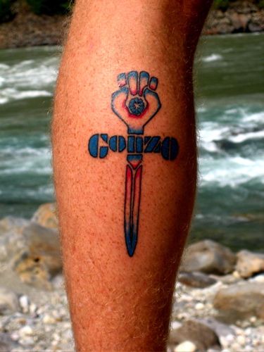 a man's leg with a tattoo on it that says gonzod in front of a river