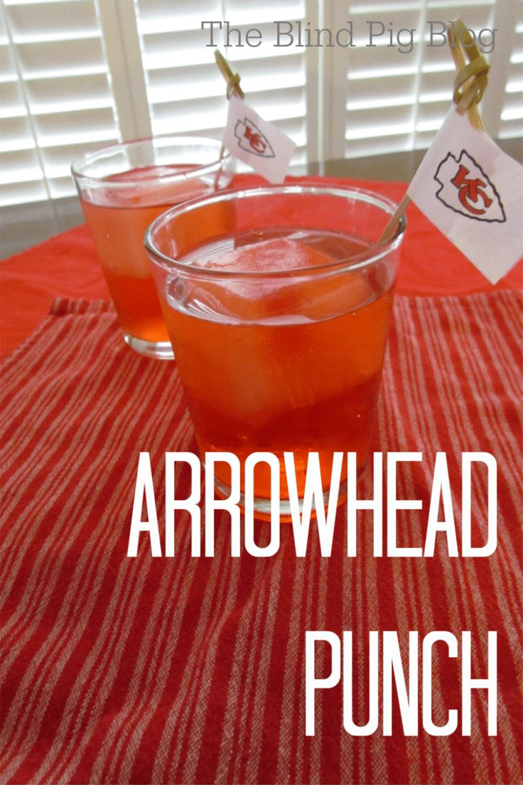 two glasses filled with liquid sitting on top of a red and white striped table cloth