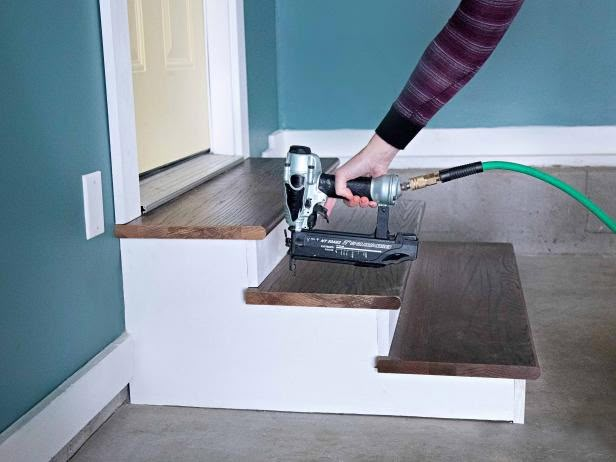 a person using a power drill to attach a piece of wood on top of some stairs