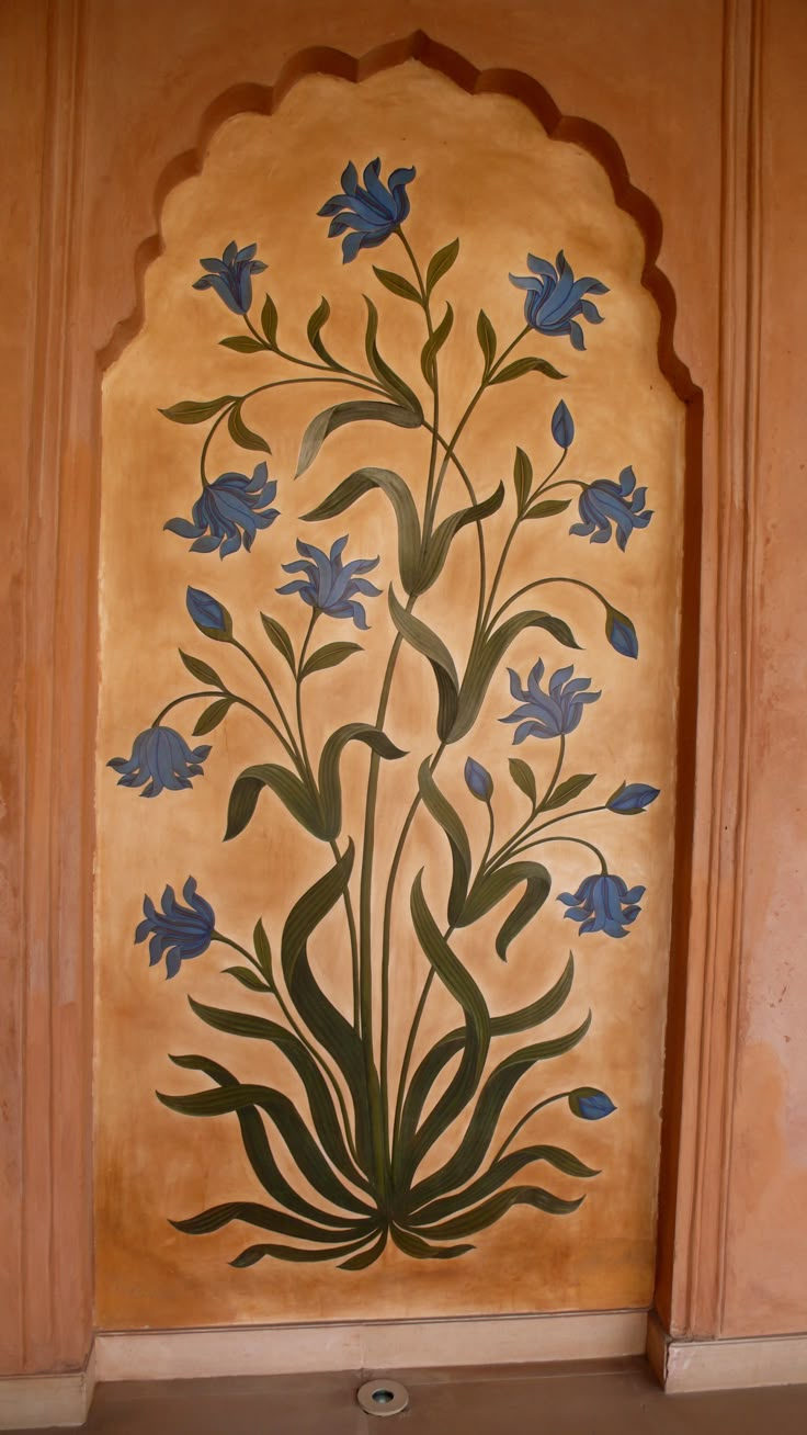 a painting on the side of a building with blue flowers and leaves painted on it