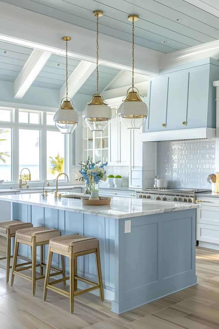 a large kitchen with blue cabinets and white counter tops, two stools in front of the island