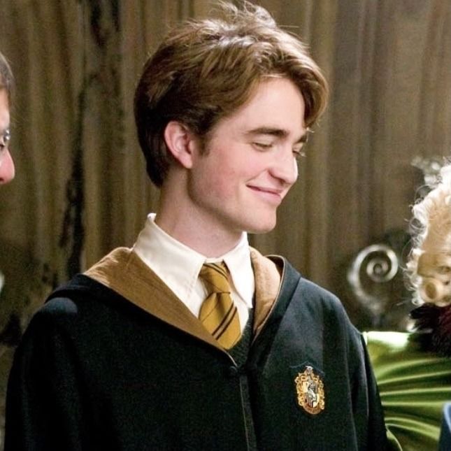 a young man wearing a harry potter outfit and looking at his cell phone while standing next to an older man