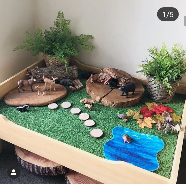 a wooden table topped with fake animals and plants