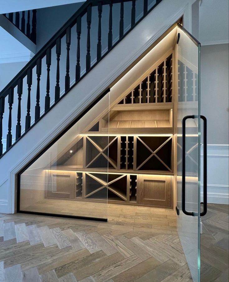 a wine cellar under the stairs in a house