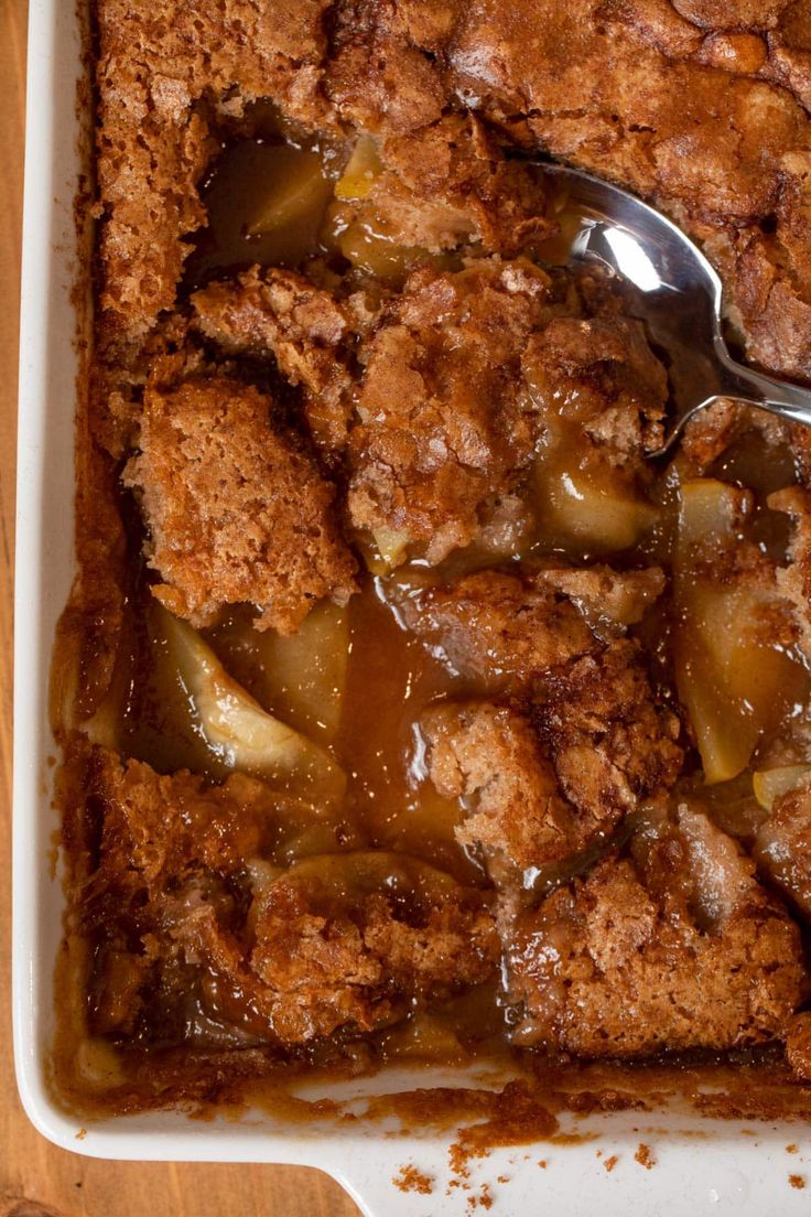 a casserole dish filled with apples and topped with crumbled toppings