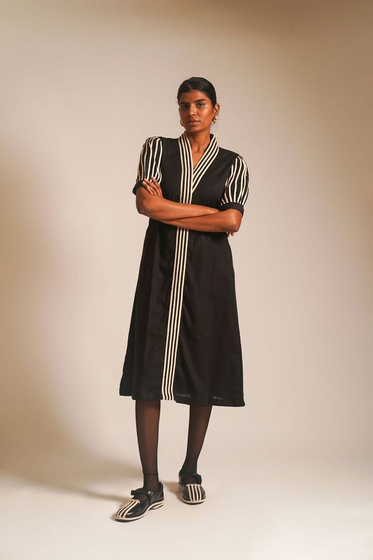 Indulge in understated glamour with our black long A-line dress in cotton fabric, a perfect union of grace and style. The overlapped neckline, adorned with intricate dori details, creates an alluring focal point. The front placket and half-puffed sleeves feature additional dori embellishments, adding a touch of sophistication. Side pockets provide a practical element, while the front hook opening adds a hint of modernity to this timeless ensemble, making it an ideal choice for any elegant affair.The model is 5'9'' and wearing S.Material: 100% CottonCare: Dryclean Only Half Sleeve Dress, Understated Glamour, Half Sleeve Dresses, Puffed Sleeves, Xl Dress, Long A Line, Half Sleeve, Half Sleeves, Sleeve Dress