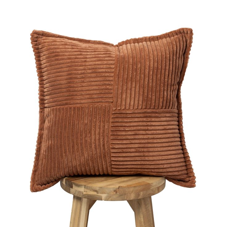 a brown pillow sitting on top of a wooden stool