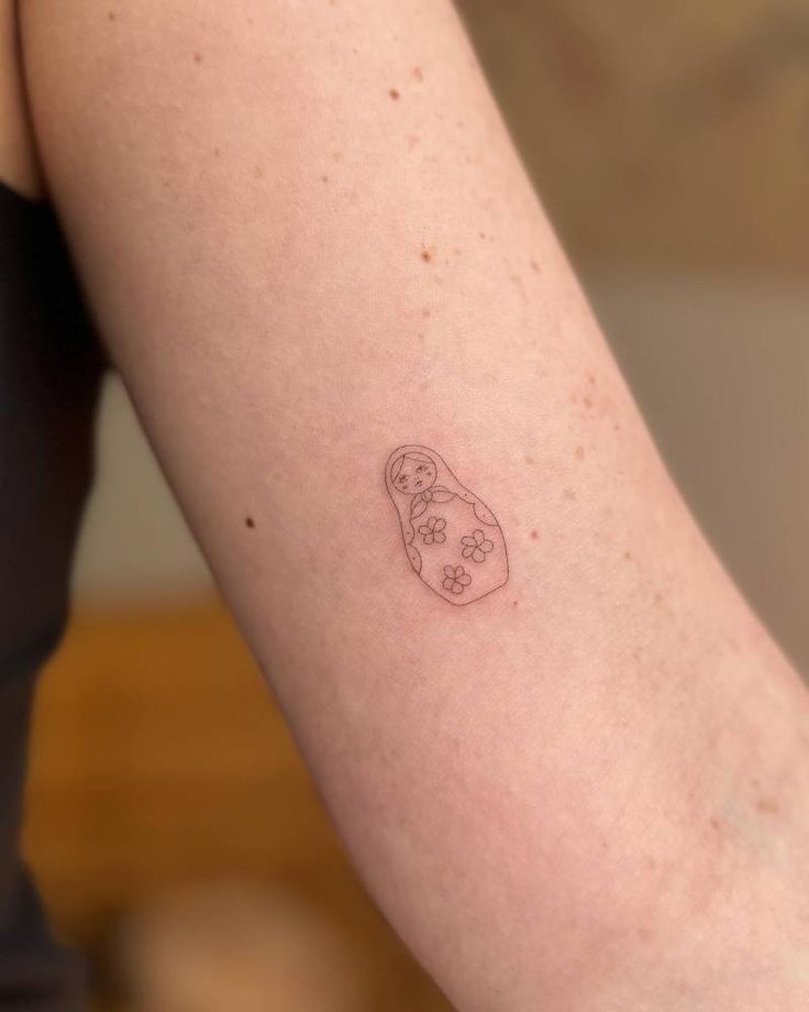 a small tattoo on the arm of a woman's left arm, with a dog paw in it