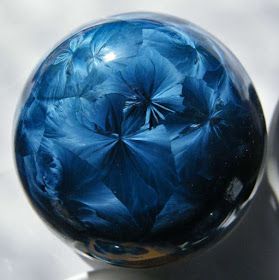 a blue glass ball sitting on top of a table