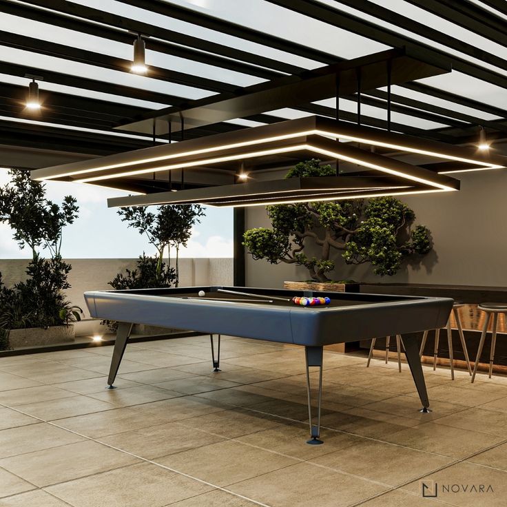 a pool table is in the middle of a room with potted plants and chairs