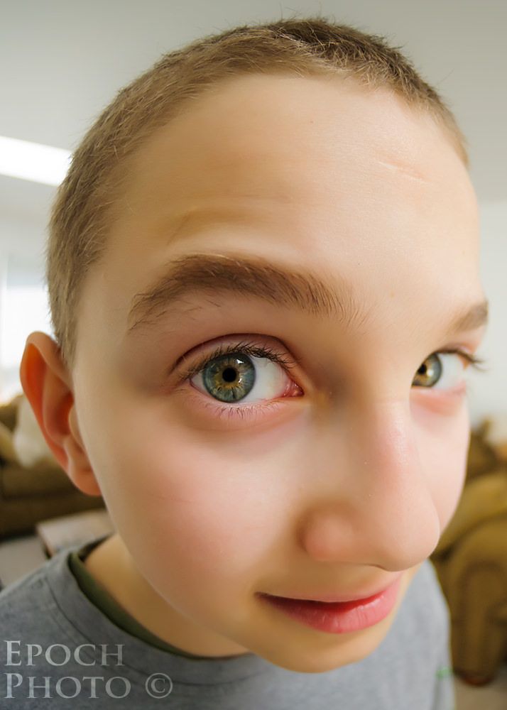 a young boy with blue eyes looking at the camera