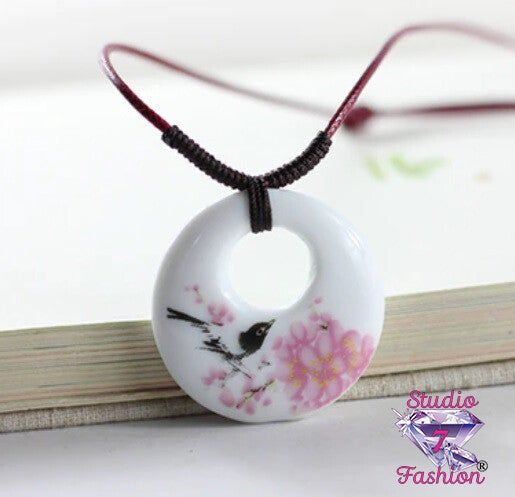 This beautiful necklace features a singing black bird and pink dogwood blossoms. The elliptical pendant is made of ceramic measuring about 1", the necklace is corded and expandable up to 24" with a slip knot. Bronze Chain Necklace, Ceramic Pendant Necklace, Ceramic Pendants, Porcelain Necklace, Pink Dogwood, Dogwood Blossoms, Asian Jewelry, Ceramic Necklace, Art Necklaces