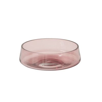 a pink glass bowl sitting on top of a white table