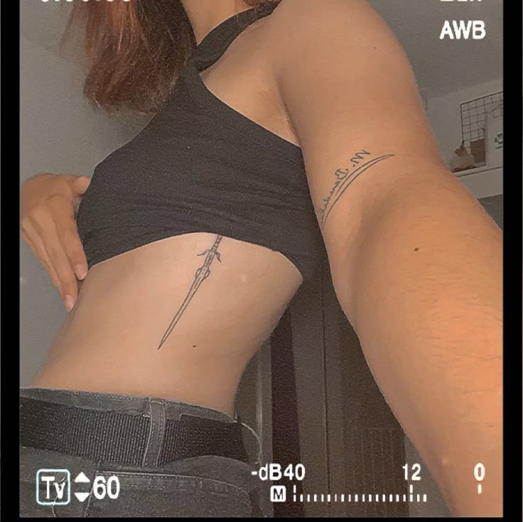 Sword tattoo, rib tattoo Rib Tattoo Under Bra Line, Long Rib Tattoo, Women Sternum Tattoo Ideas, Vertical Side Tattoo, Upper Rib Tattoo, Side Of Rib Tattoo Women, Side Ribcage Tattoo, Side Ribs Tattoo, Vertical Rib Tattoo