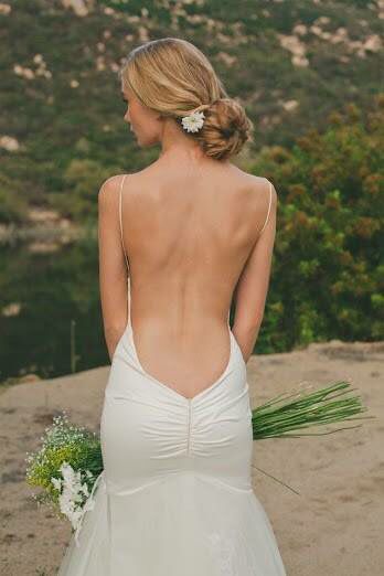 a woman in a wedding dress looking at the mountains