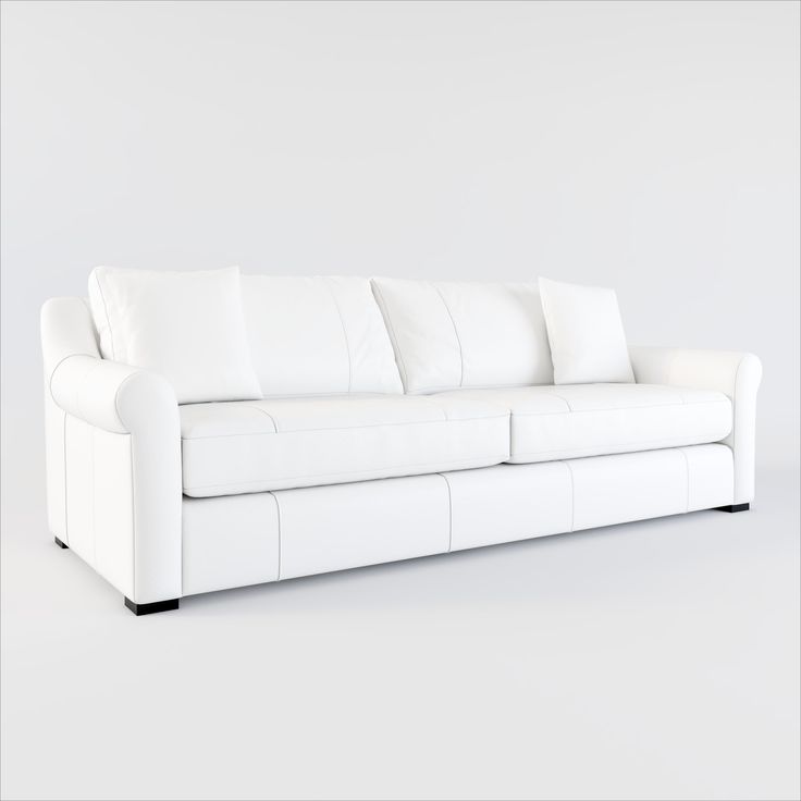 a white leather couch with four pillows on it's back end and one arm