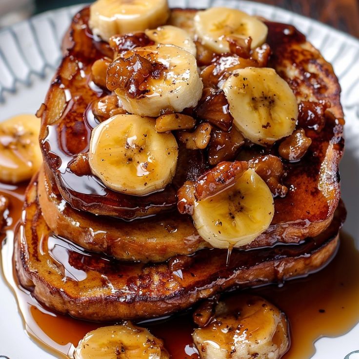 pancakes covered in bananas and syrup on a plate