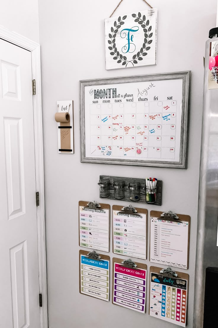 a kitchen wall with calendars and magnets on the door way to a room