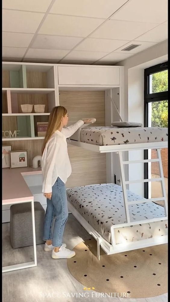 a woman standing next to a bunk bed in a room