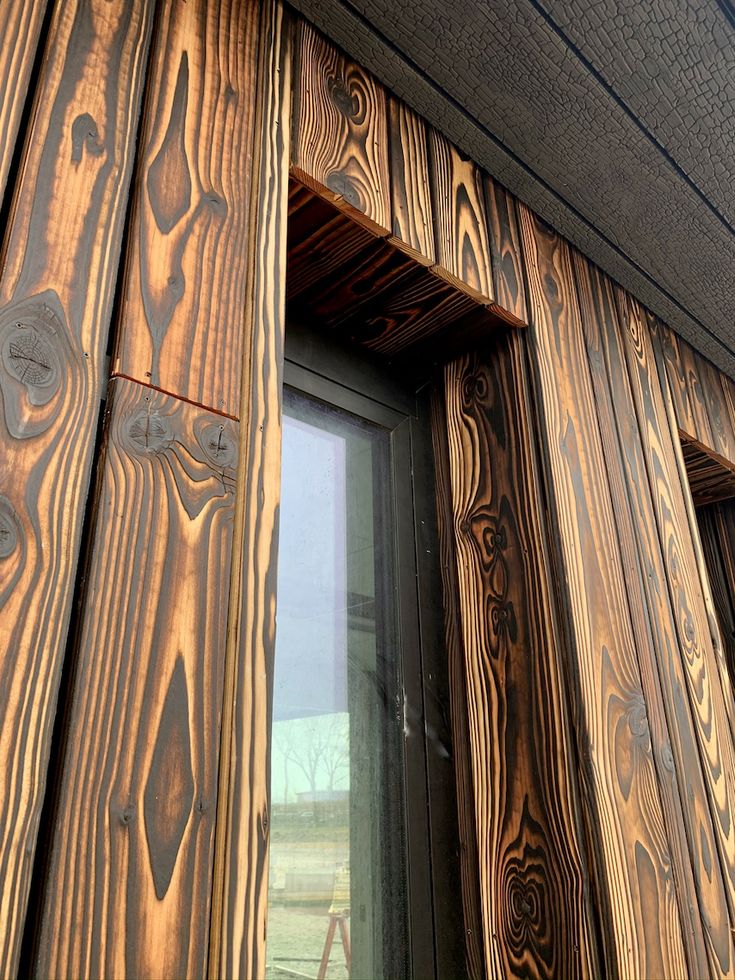 the side of a house with wood siding and window frames on it's sides