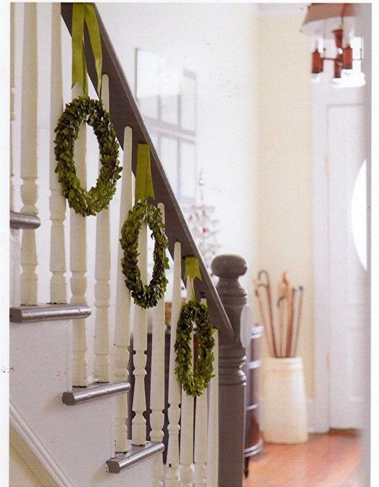 two wreaths are hanging on the banister