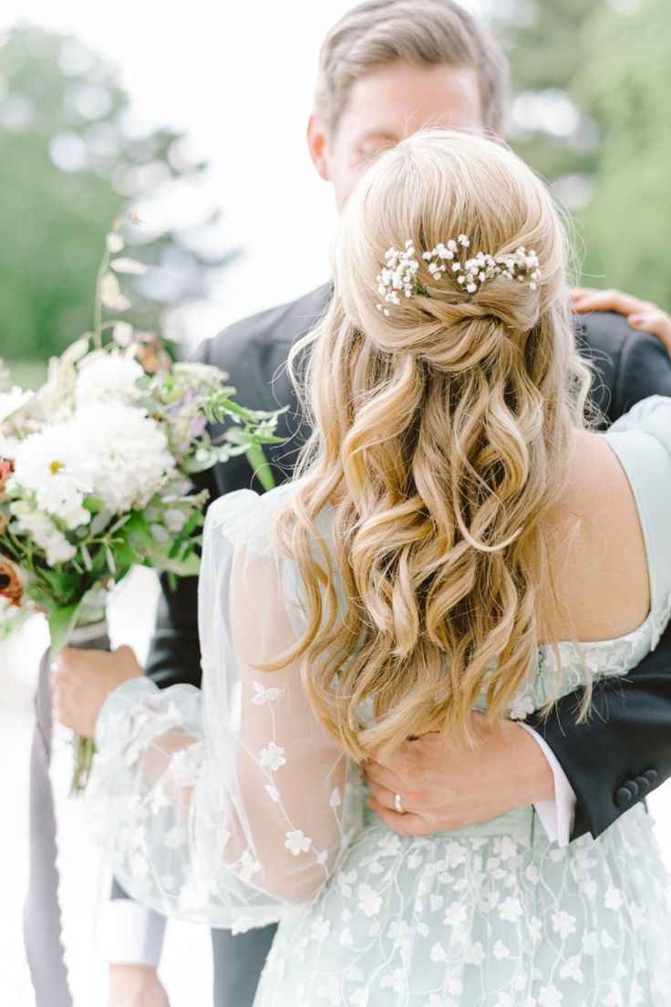 a bride and groom embracing each other with flowers in their hair at the end of their wedding day