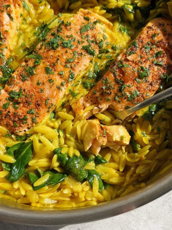 a pan filled with pasta and salmon on top of a table