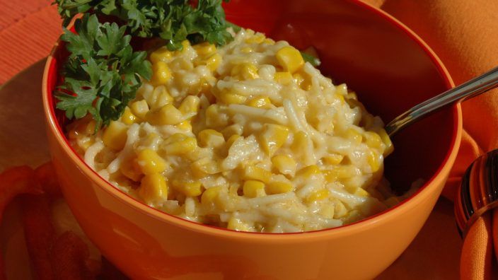 a bowl filled with macaroni and cheese, garnished with parsley