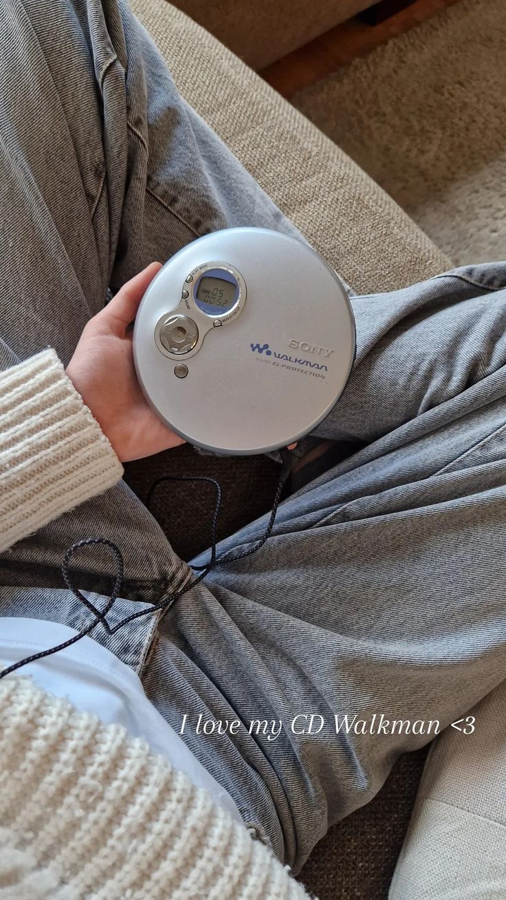 a person sitting on a couch holding an electronic device