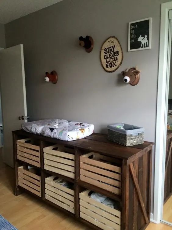 a baby crib in the corner of a room with wooden crates and baskets on it