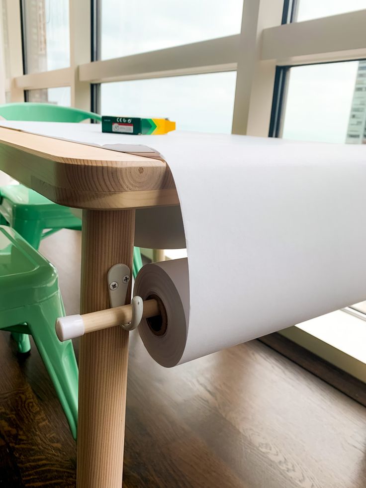 a close up of a roll of paper on a wooden table with a window in the background