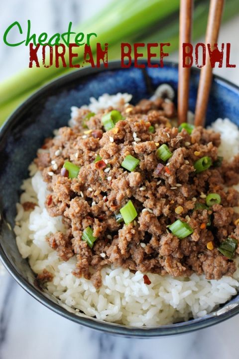 a blue bowl filled with white rice and meat next to chopsticks in it