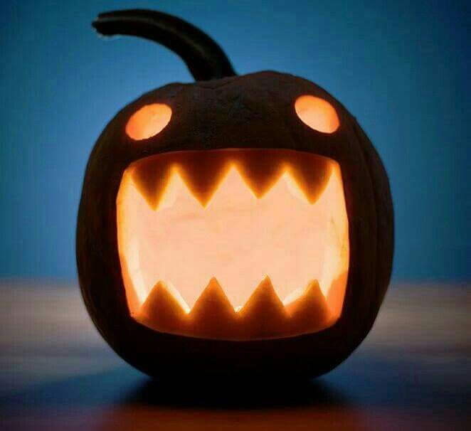 a carved pumpkin with teeth and glowing eyes