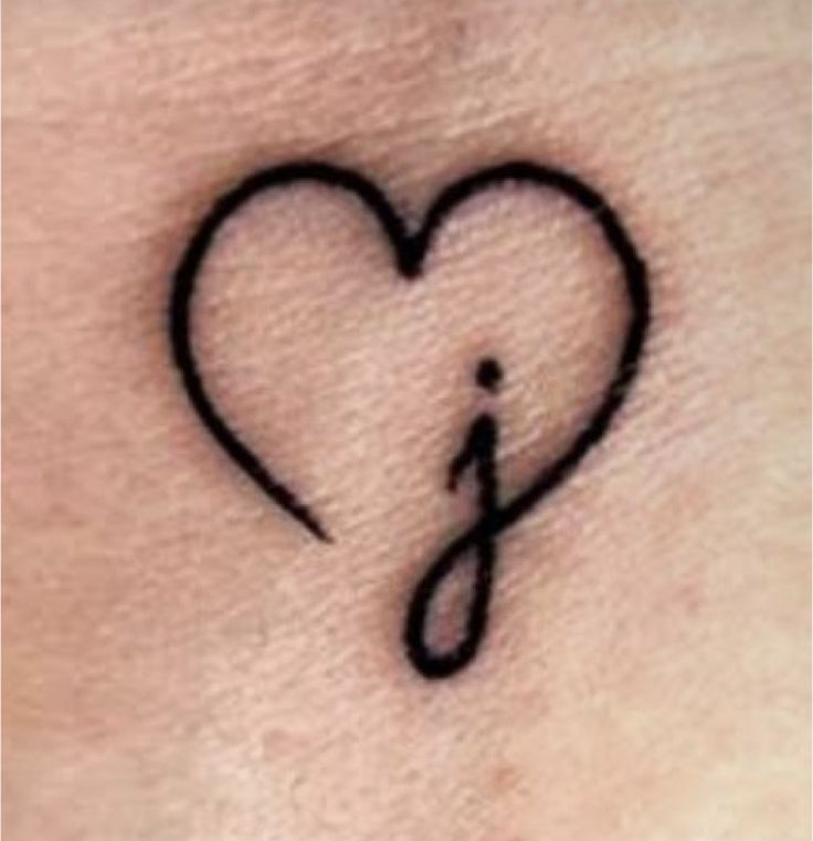 a small tattoo on the back of a woman's stomach, with an arrow in the shape of a heart