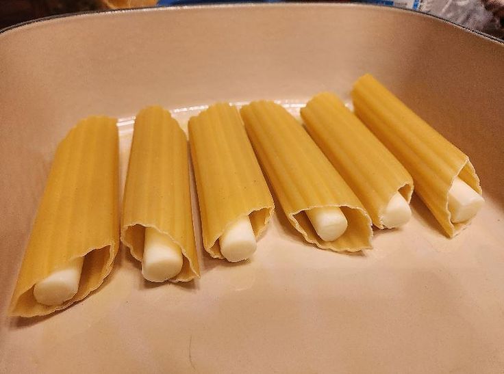 four uncooked pieces of pasta sitting in a pan on top of a table