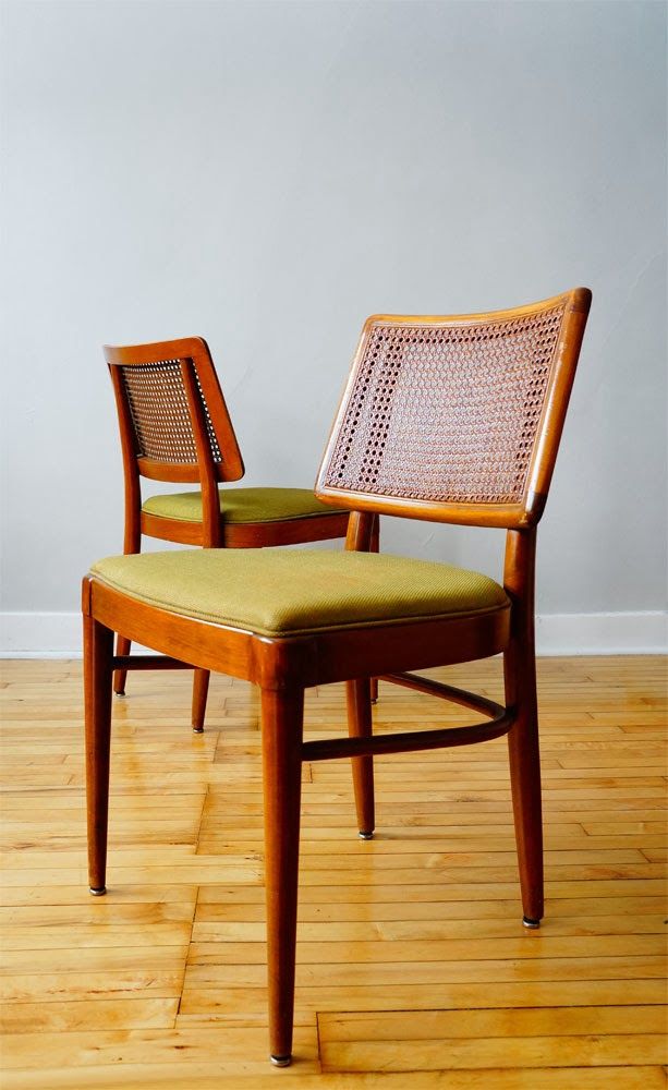 two chairs sitting on top of a hard wood floor next to each other in front of a white wall