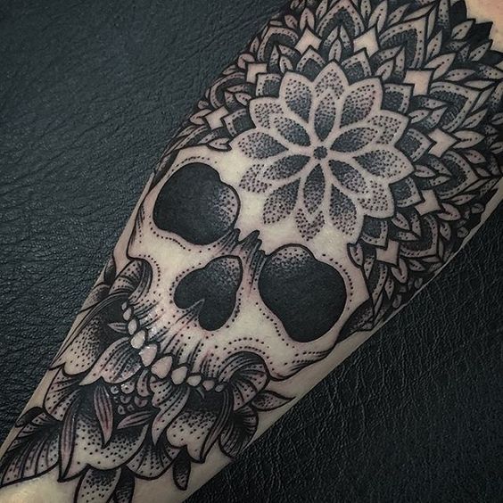 a black and white tattoo with skulls on it