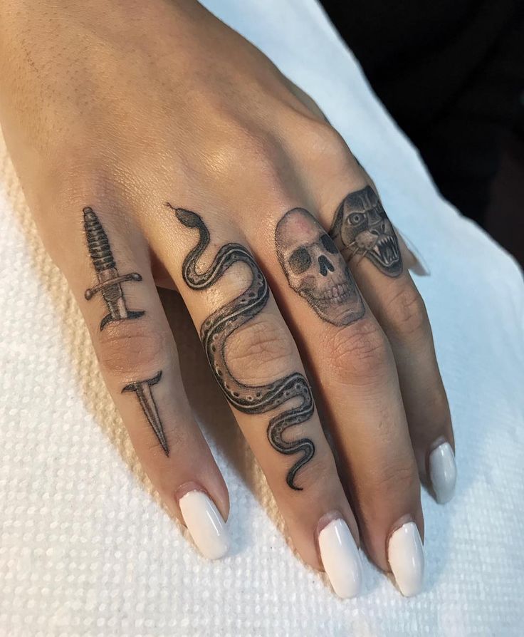 two hands with tattoos on them, one has a snake and the other has a skull