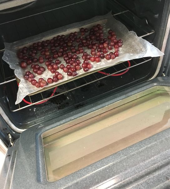 grapes are being cooked in the oven on tin foil and ready to go into the oven