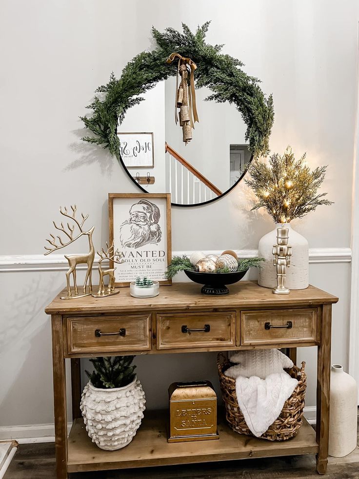 a wooden table topped with a mirror next to a plant and potted pine tree