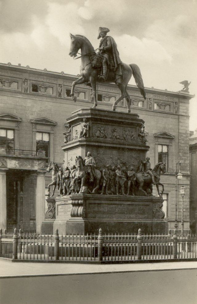 an old black and white photo of a statue in front of a building