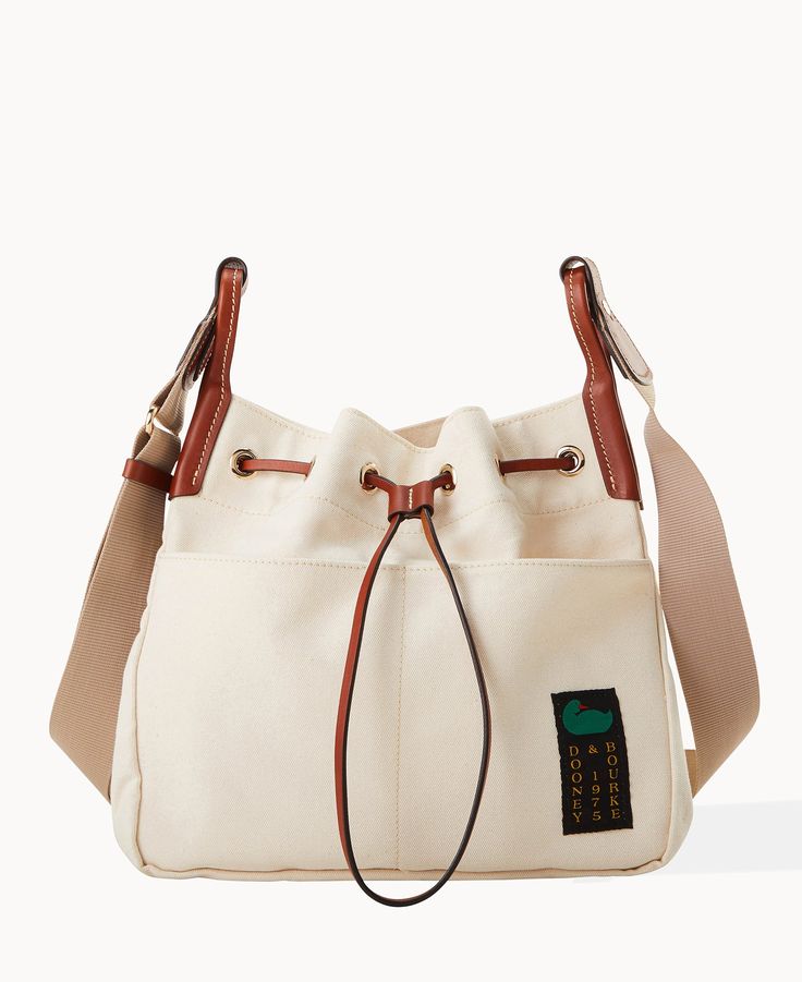 Keeping It Casual This casual-chic look is crafted from 100% Egyptian cotton. With effortless Dooney flair and so many functional additions, this is the perfect every day bag! Four outside pockets. Adjustable straps. Drawstring closure. | Dooney & Bourke Women's Canvas Drawstring 30 Fabric Shoulder Bag in Natural Cream Bucket Satchel For Everyday, Everyday Cream Bucket Satchel, Canvas Bucket Shoulder Bag With Pockets, Cream Bucket Bag With Detachable Strap For Errands, Casual Cream Bucket Bag With Detachable Strap, Casual Cream Hobo Bag With Removable Pouch, Travel Shoulder Bag With Pockets In Bucket Shape, Beige Shoulder Bucket Bag With Pockets, Everyday Canvas Bucket Bag With Detachable Strap