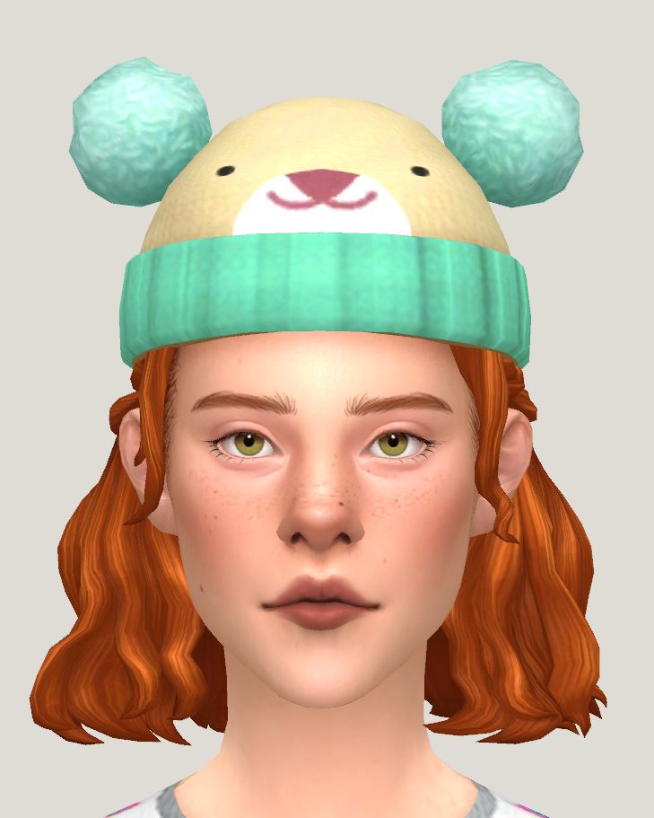 a girl with red hair wearing a beanie hat and green ear covers on her head