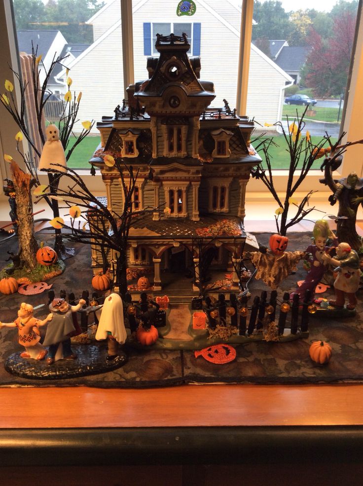 a house with lots of halloween decorations on the windowsill