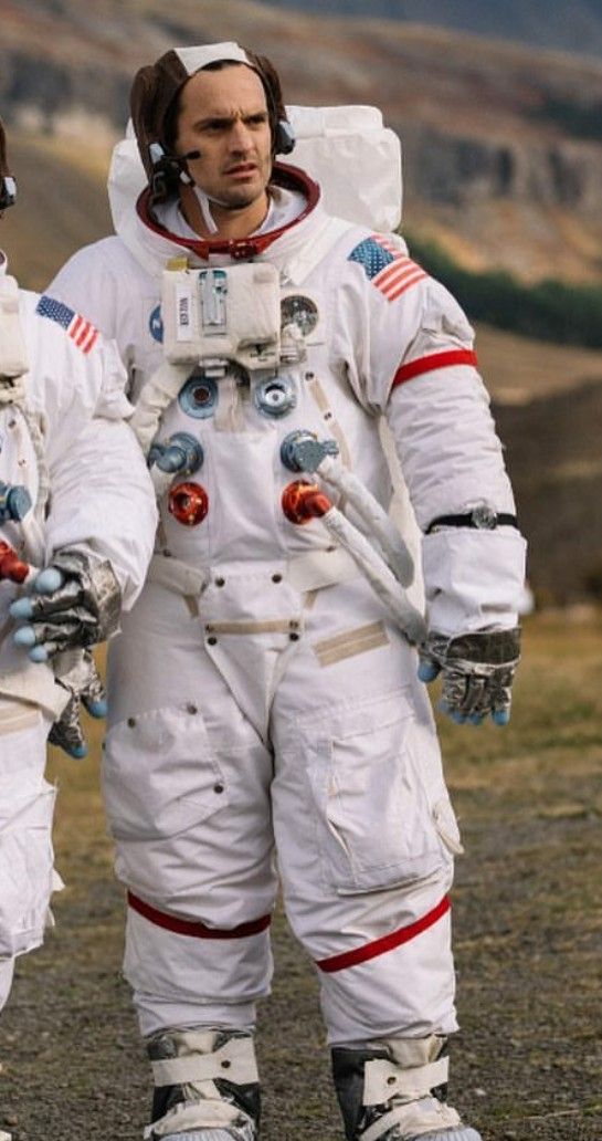 two men in white spacesuits standing next to each other