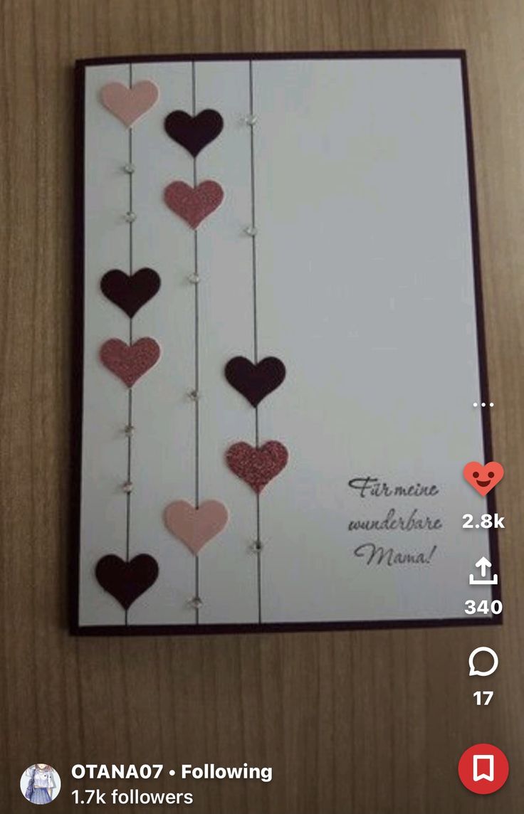 a card with hearts hanging from strings