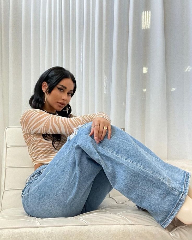 a woman sitting on top of a white couch