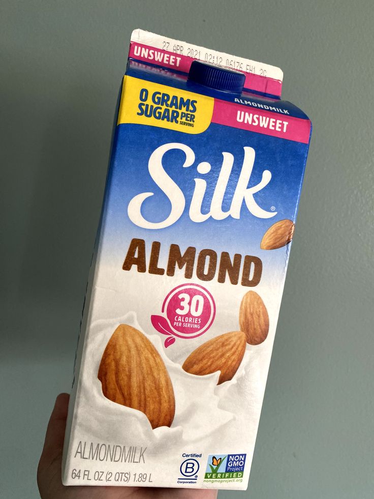 a hand holding up a box of silk almonds