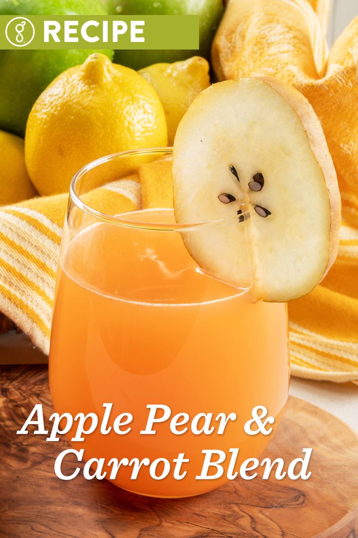 an apple pear and carrot blend in a glass on a cutting board next to sliced oranges