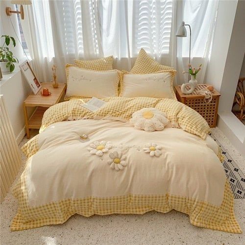 a bed with yellow gingham sheets and flowers on the comforter is in front of a window